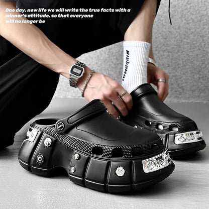 Person wearing black platform clogs with decorative elements on a neutral background