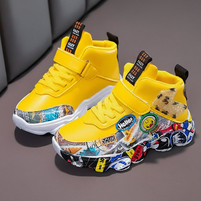 A pair of yellow high-top sneakers with colorful cartoon and sticker graphics on the soles, displayed on a gray surface with a gray chair in the background. The text 'HUMOR RABBIT' is visible in the top left corner.