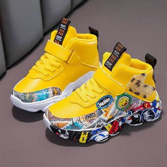 A pair of yellow high-top sneakers with colorful cartoon and sticker graphics on the soles, displayed on a gray surface with a gray chair in the background. The text 'HUMOR RABBIT' is visible in the top left corner.