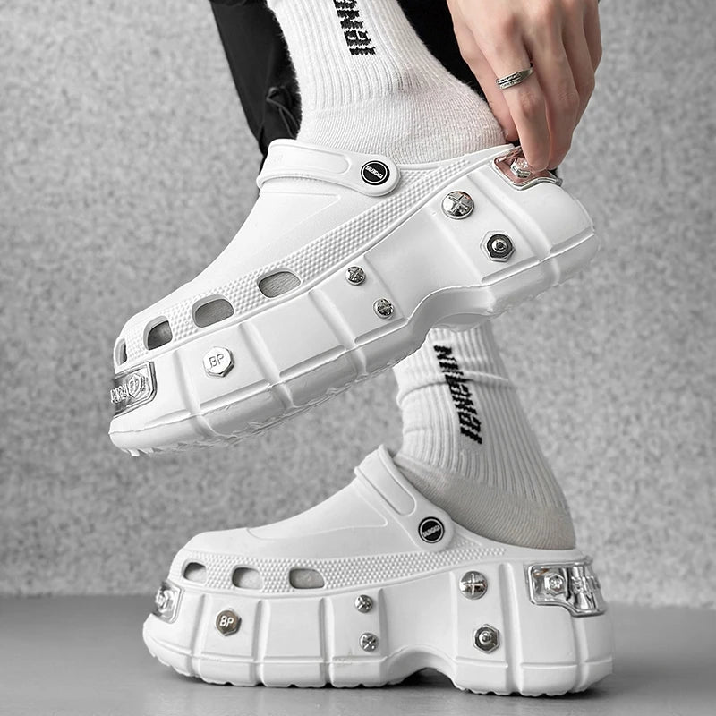 White platform clogs with decorative studs worn with white socks on a neutral background