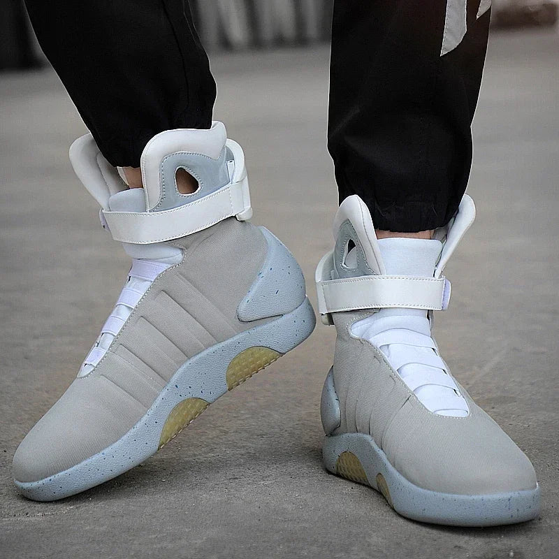 Light gray sneakers with white laces worn by a person on a concrete surface