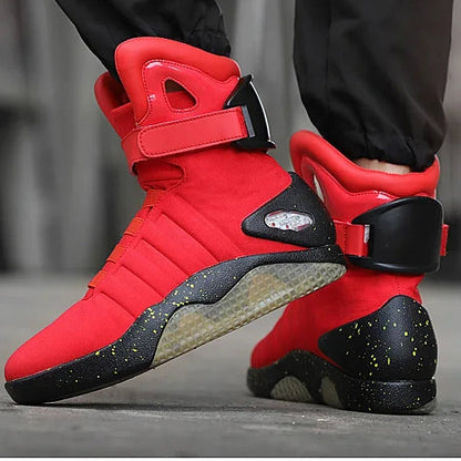 Red and black high-top sneakers with a strap held by a person, displayed against a blurred background.