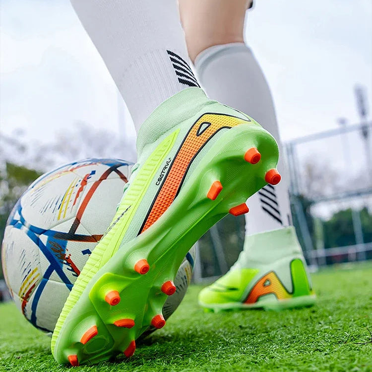 Green soccer cleats with orange studs on grass, close-up of foot and ball.