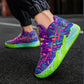 Colorful sneakers with pink and green accents worn on a dark surface